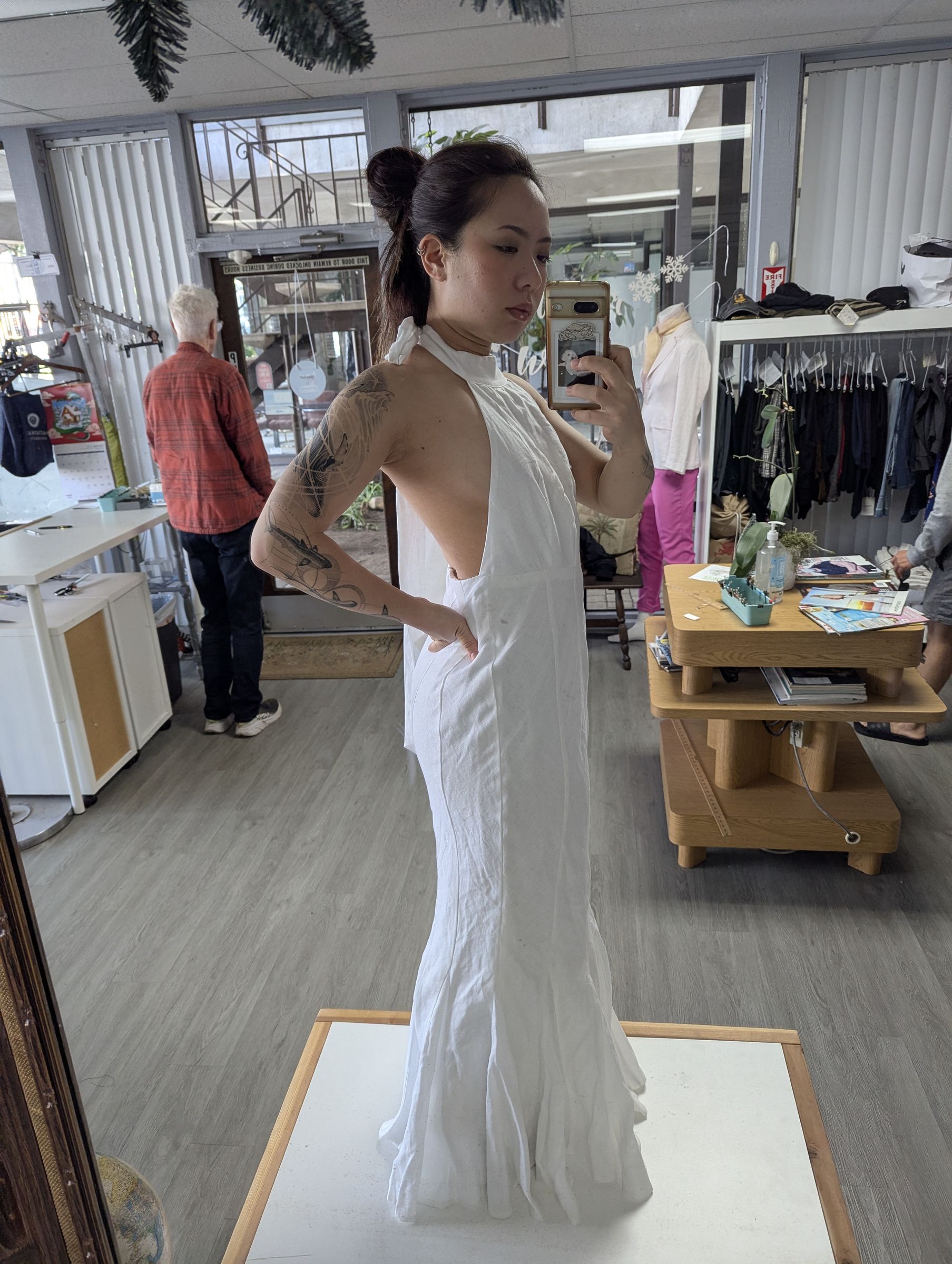 Customer trying on a fitted white gown on the fitting platform